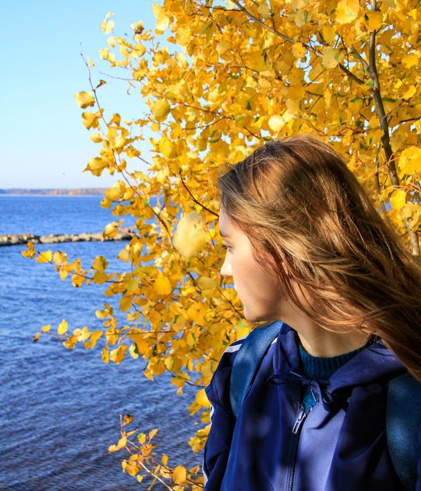 Young woman looking calmly into the distance near lake.